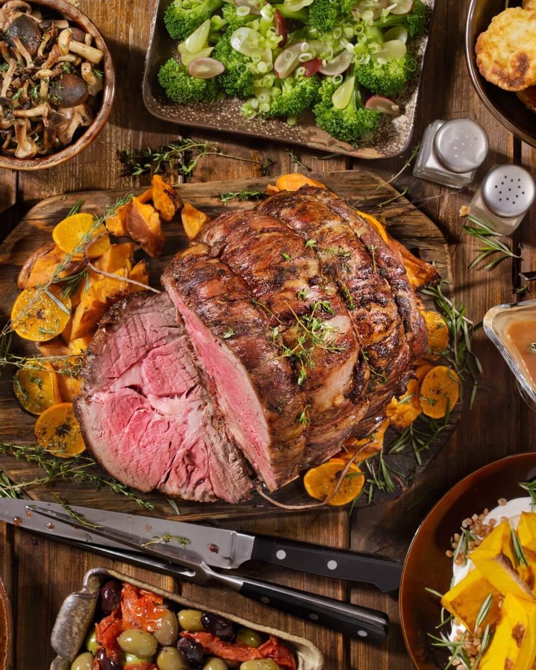 A roasted leg of lamb on a bed of roasted pumpkin